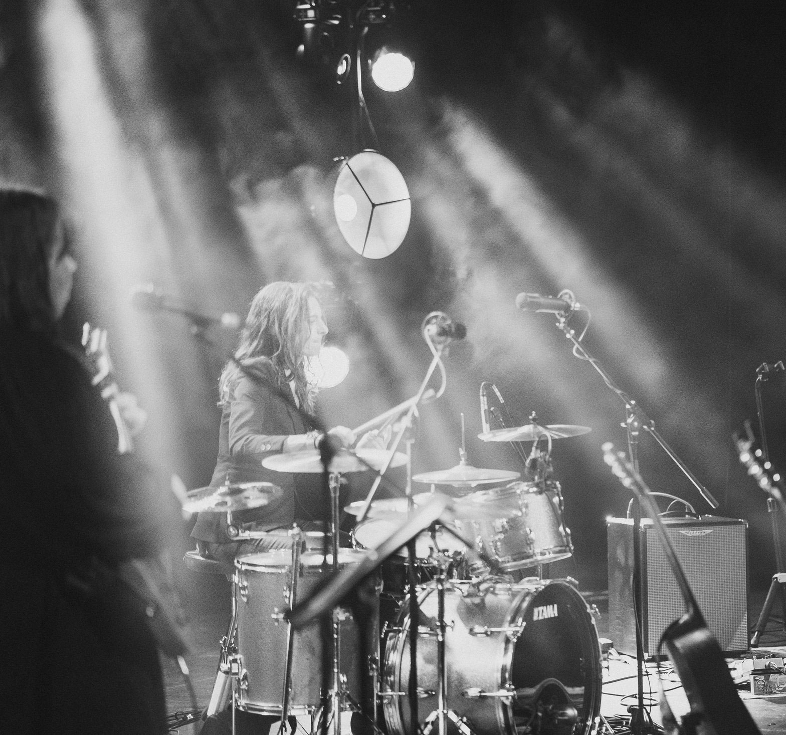 Gail James at the kit under stage light, black and white